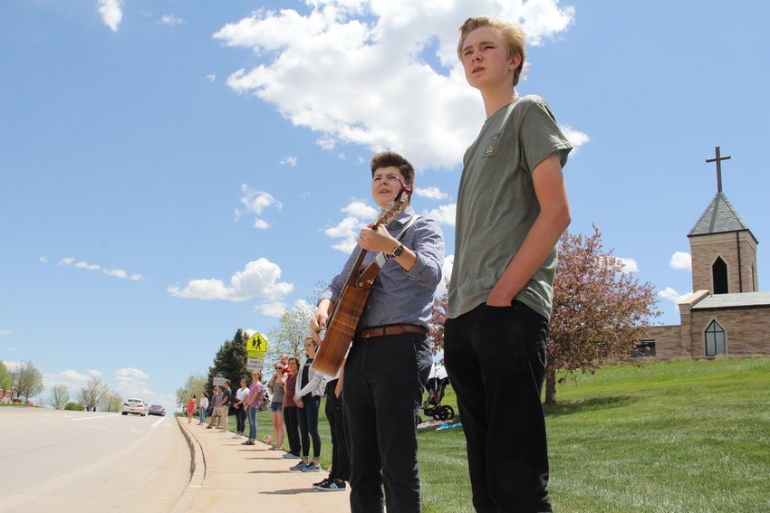 Bendor Shallow, right, and Connor LeFebre, with the guitar, stand in a line of Valor Christian High School students awaiting a motorcade to arrive at a May 15 memorial service for Kendrick Castillo. Shallow and LeFebre are on student council at Valor, which stands across the street from Cherry Hills Community Church, the service’s venue.